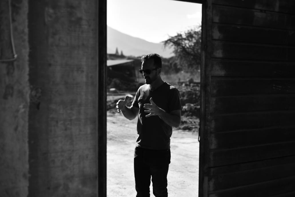 Read Spear speaking in the doorway of a rural production site in Oaxaca
