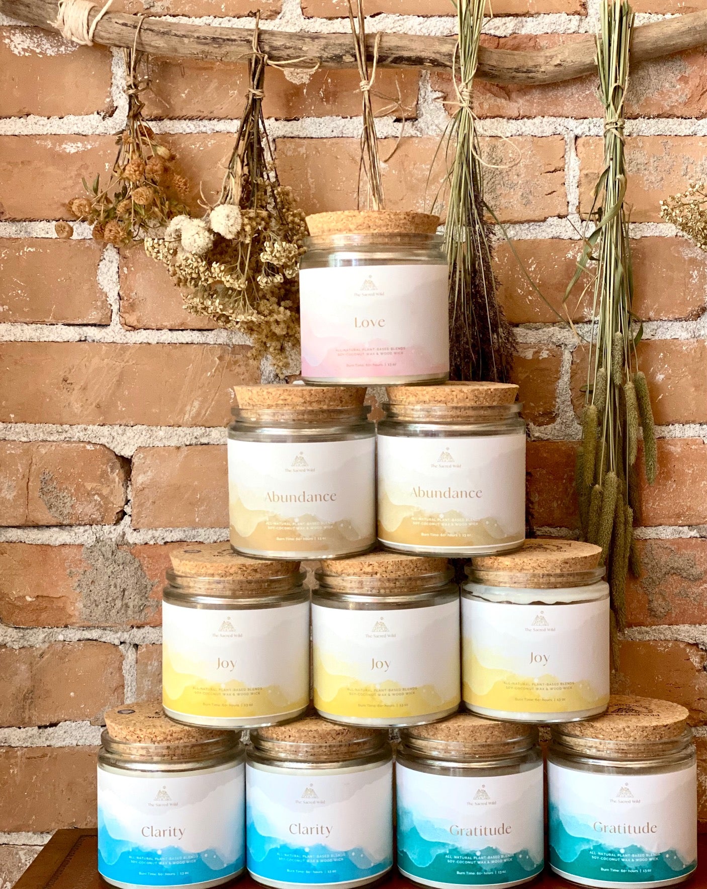 Sacred Wild Goods intention candles arranged with dried botanicals